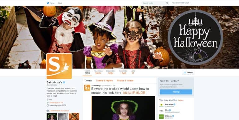Happy children in Halloween costumes celebrating outdoors at night with pumpkins and spooky decorati.