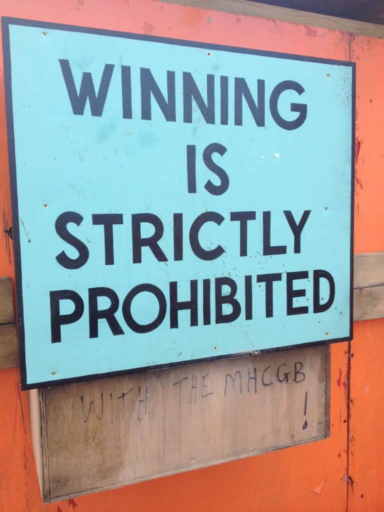 Bright blue sign reading "Winning is strictly prohibited" with bold black text.