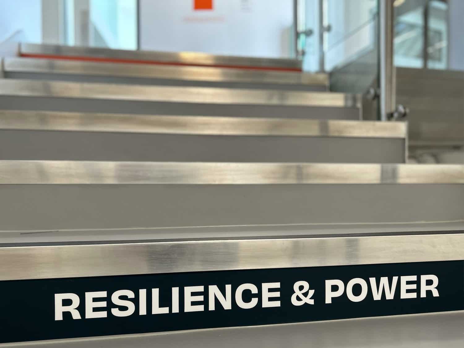 Resilience and power motivational staircase with metal steps and safety handrails.