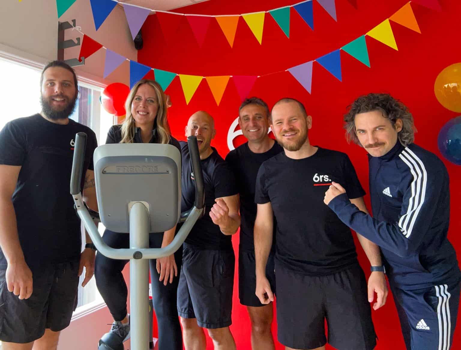 High-energy group fitness class with diverse participants celebrating success at 6rs gym.