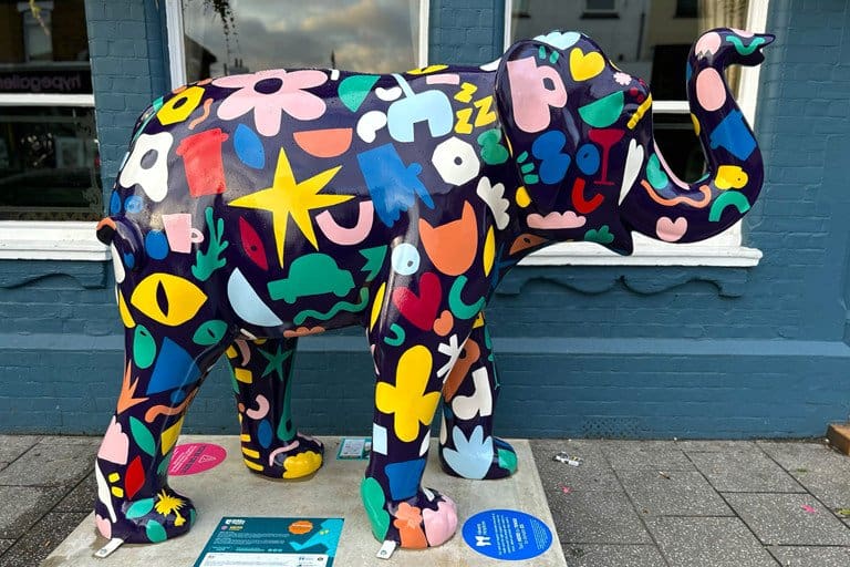 Brightly painted elephant sculpture with colourful abstract patterns and shapes.