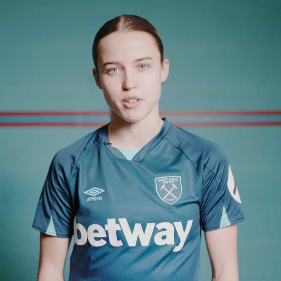West Ham United female football player in blue kit, promoting women's sports and team spirit.