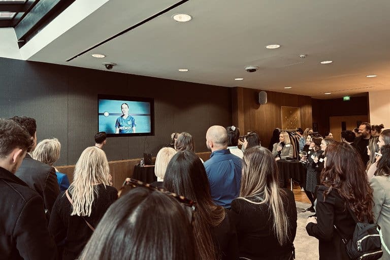 Business presentation with audience watching a speaker on screen at a conference.