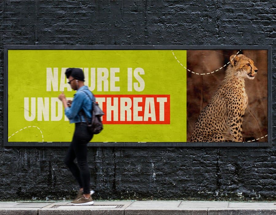 A person walking past a billboard with a cheetah image and environmental message.