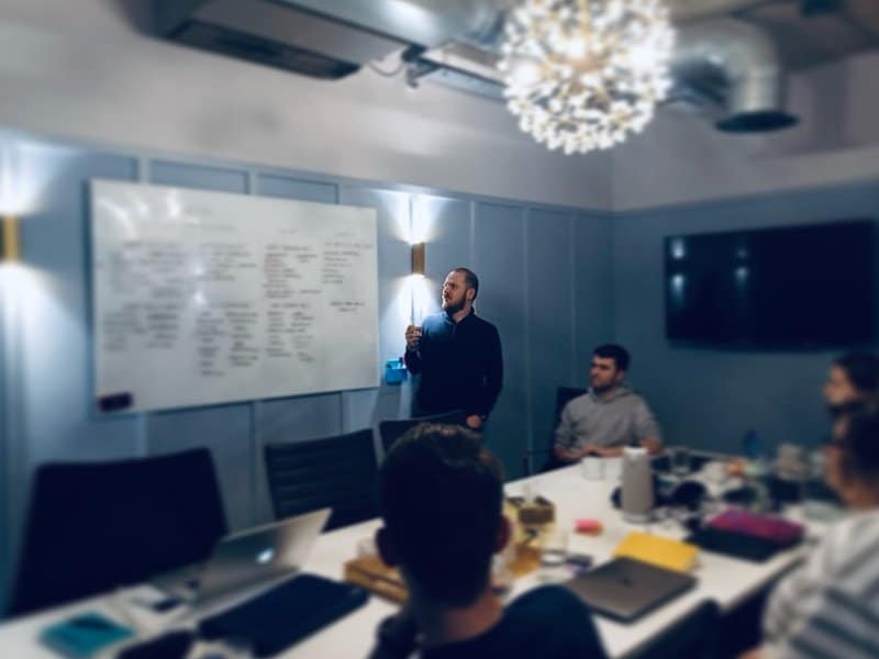 A professional business meeting or presentation in a modern conference room with team members.