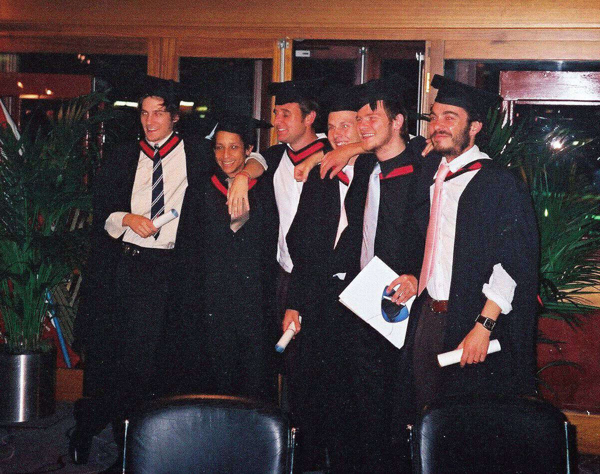 Graduates celebrating at a graduation ceremony in caps and gowns.